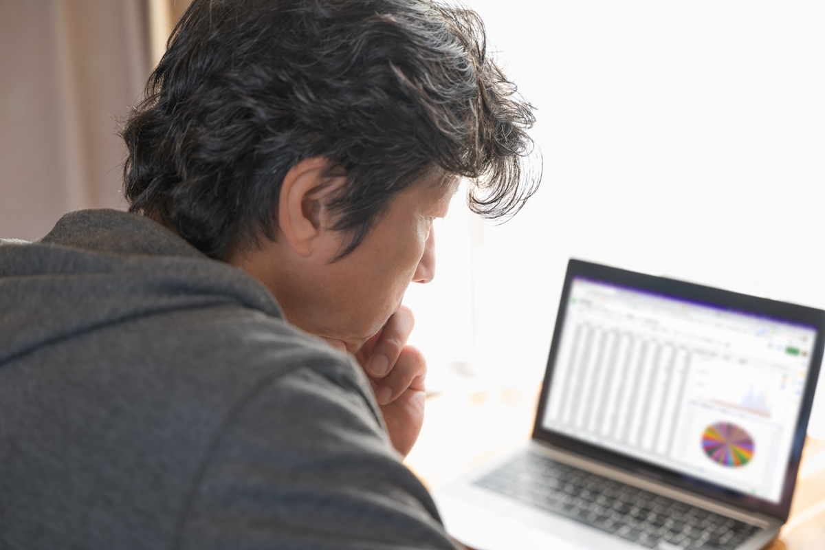 パソコンを前に悩む中年男性