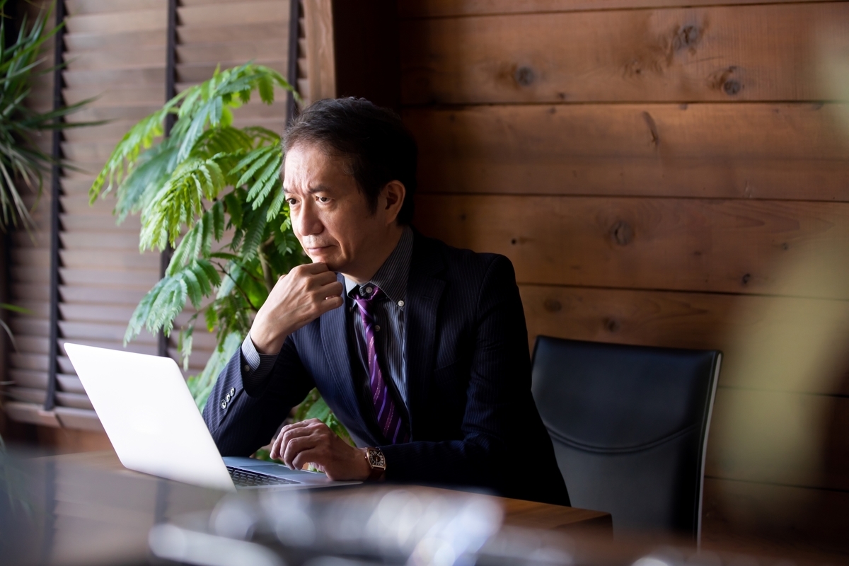 パソコンを前に考える男性