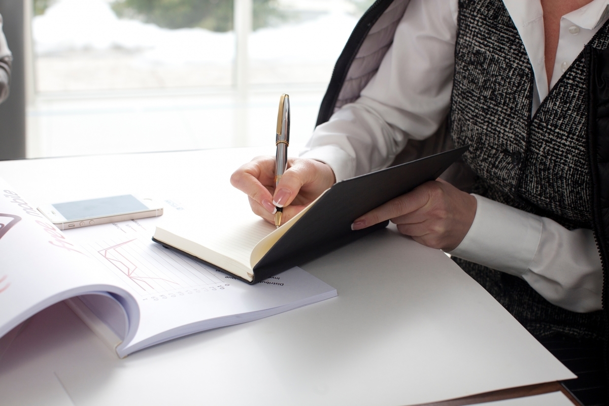 手帳に記入しながら作業をする男性