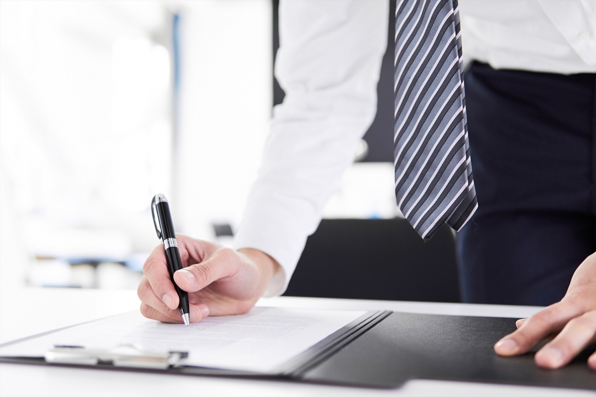資料に記入するスーツの男性