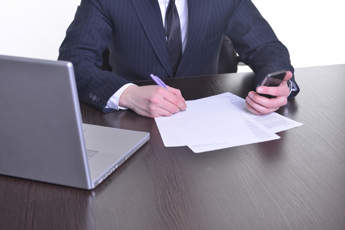 デスクで資料を記入する男性