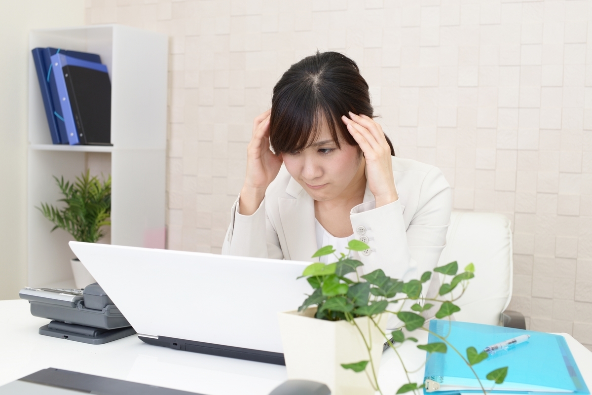 デスクで頭を抱える女性