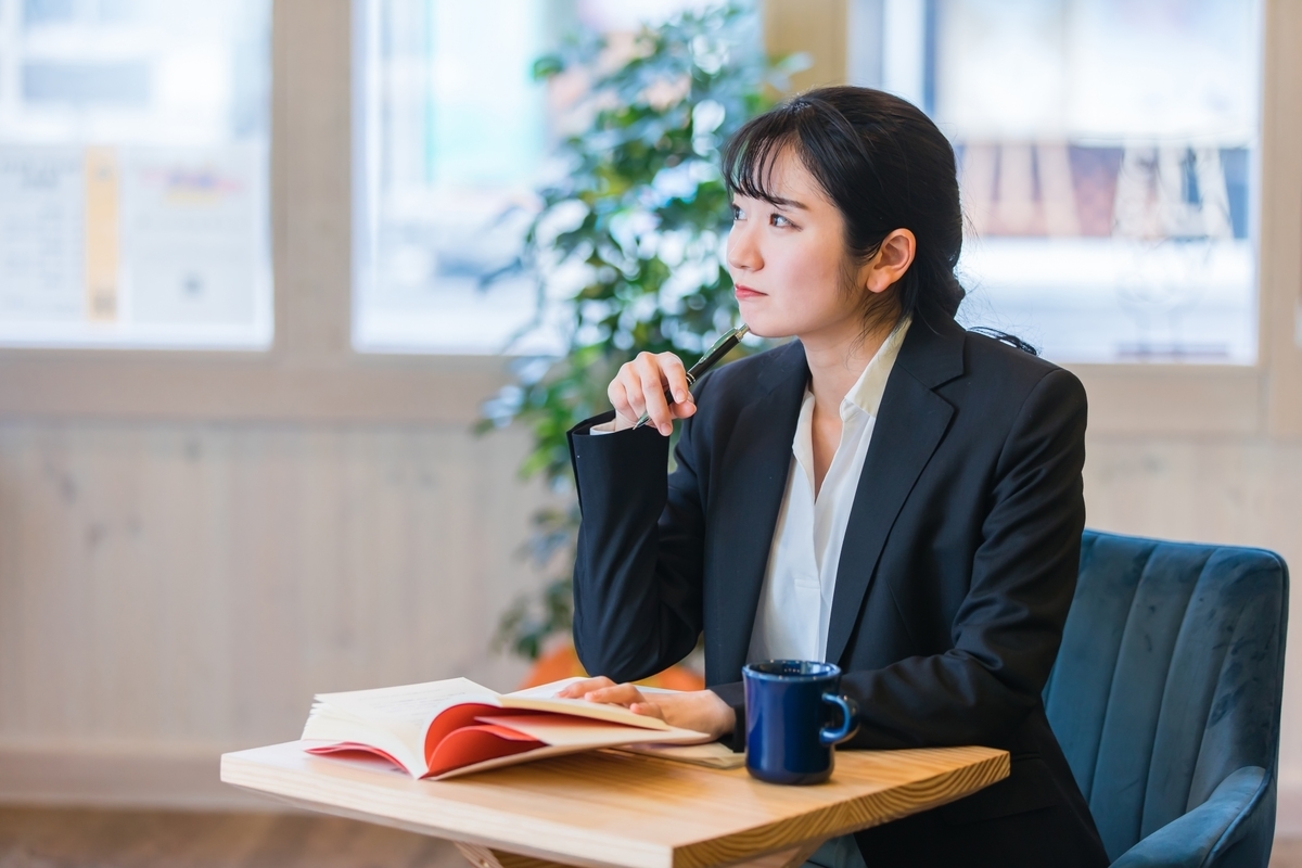 本を開いて考え事をしている女性