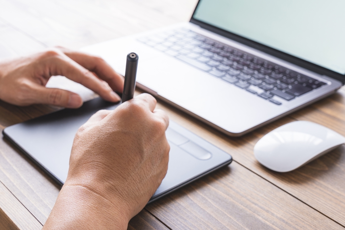 ペンツールで描いている男性の手元