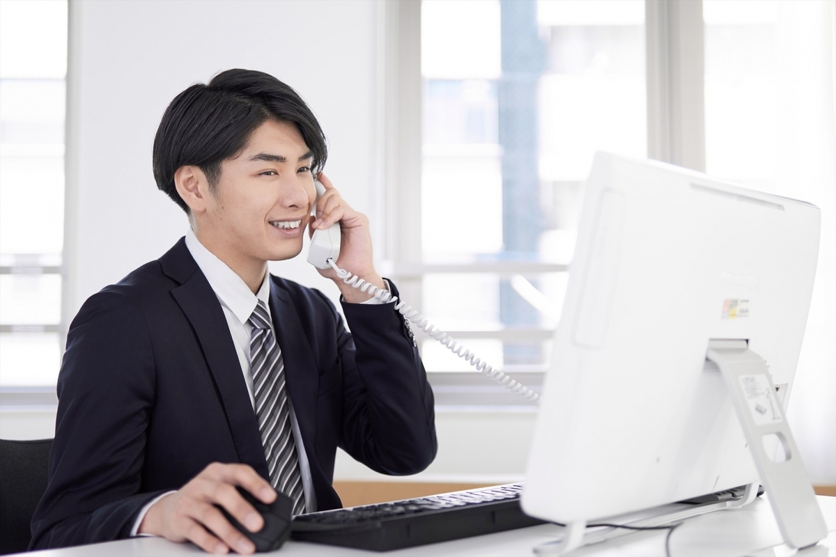 パソコンを見ながら会話をする男性