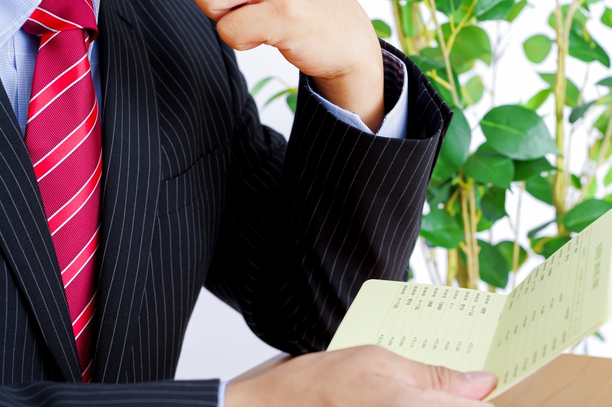 通帳を眺める男性