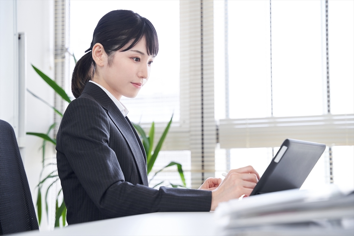 タブレットを見て操作する女性