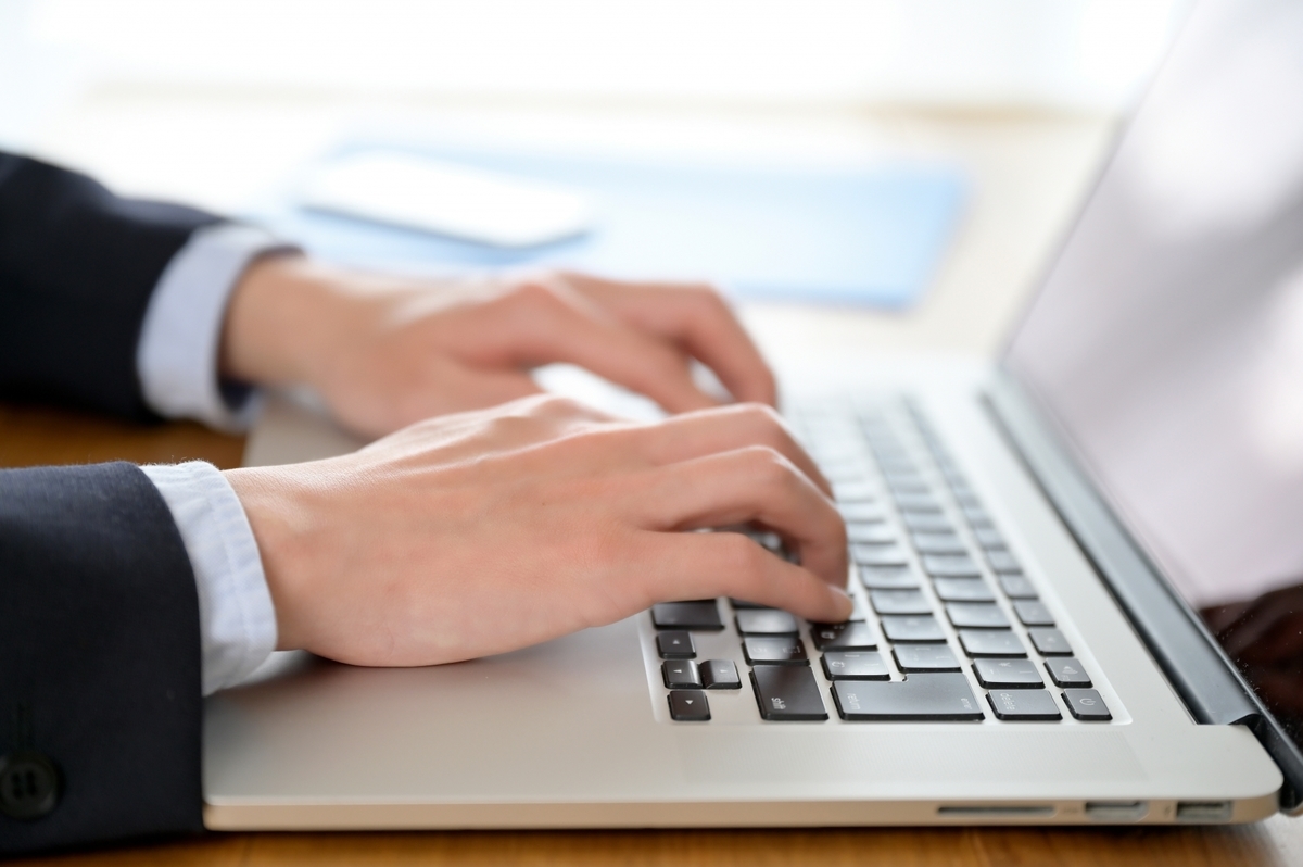 ノートパソコンを操作する手元