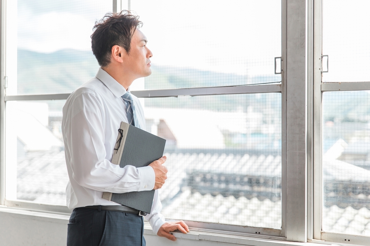 窓の外を見る教員