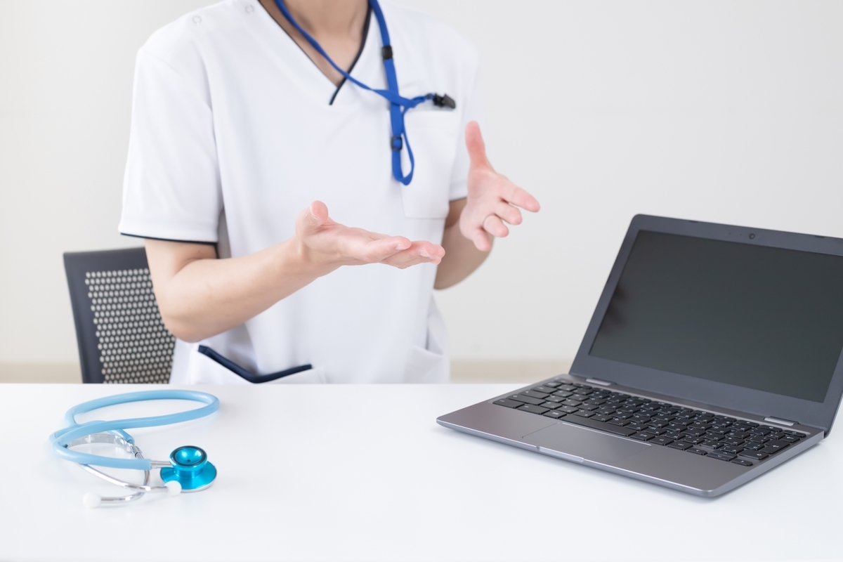 パソコンを前に話をする看護師