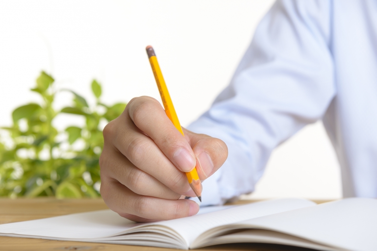 ノートに書き込む男性