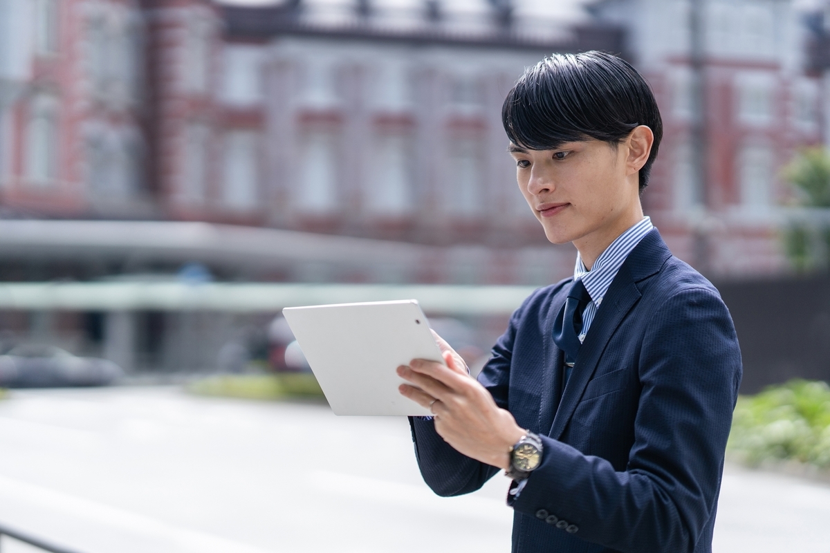 タブレットを使うスーツの男性