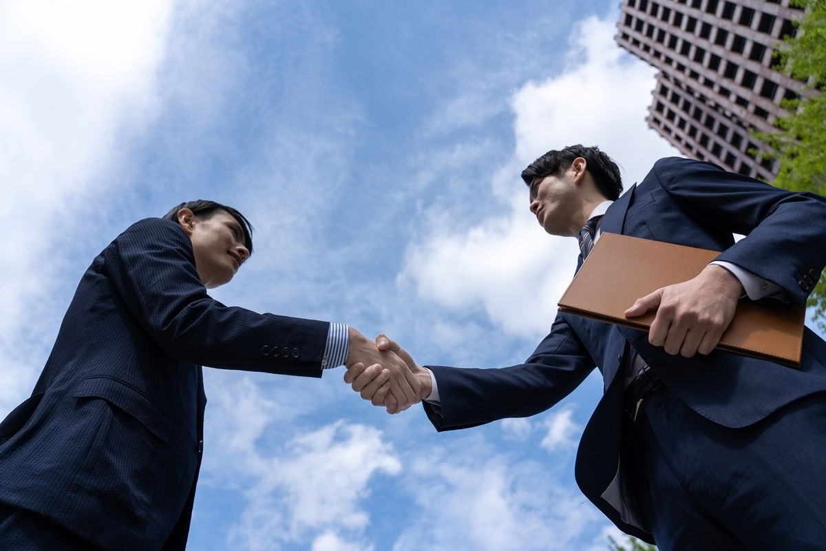 握手をする二人のビジネスパーソン