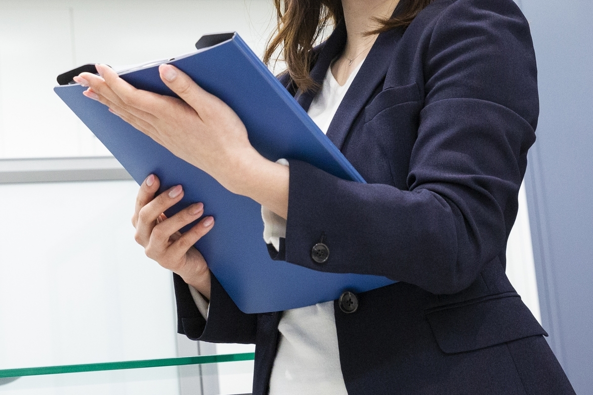 バインダーを手にしている女性