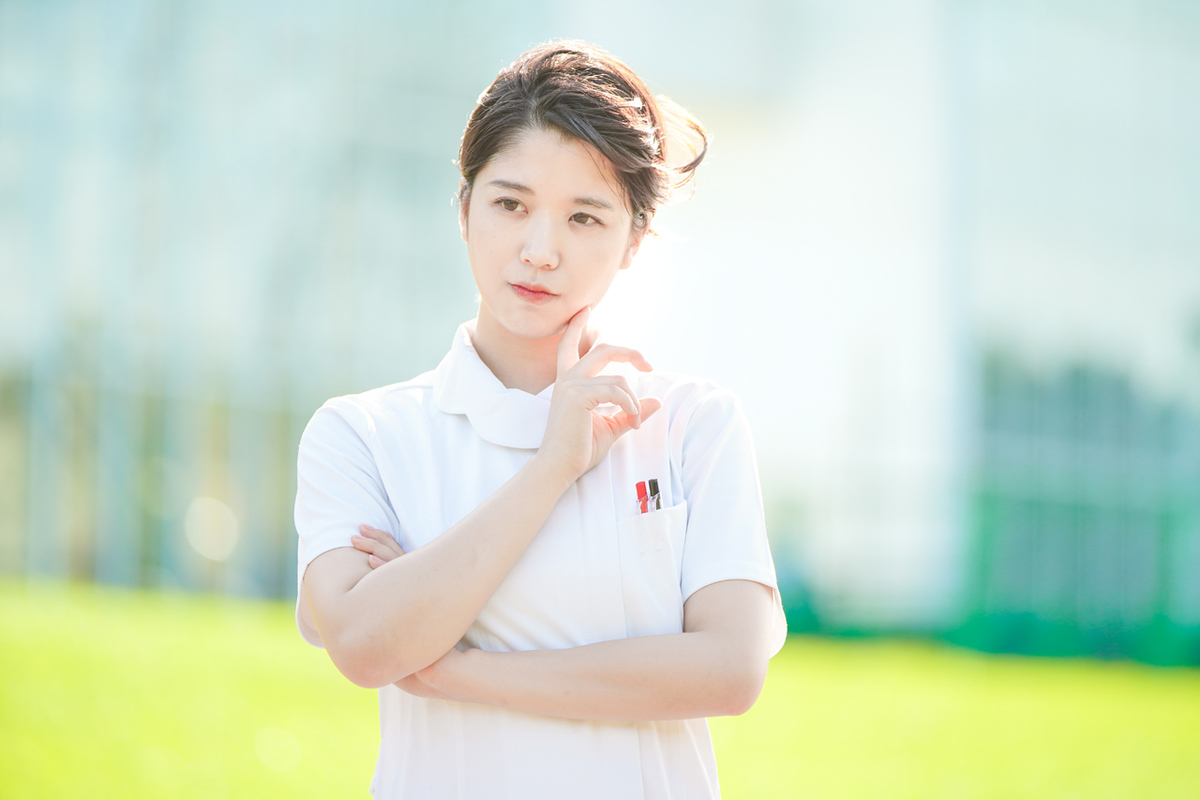 考え事をする白衣の女性