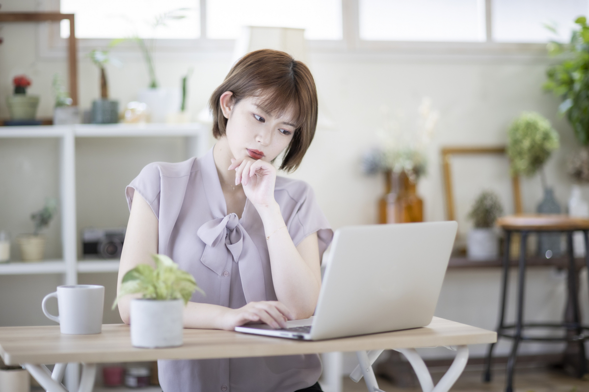パソコンを見て悩む女性