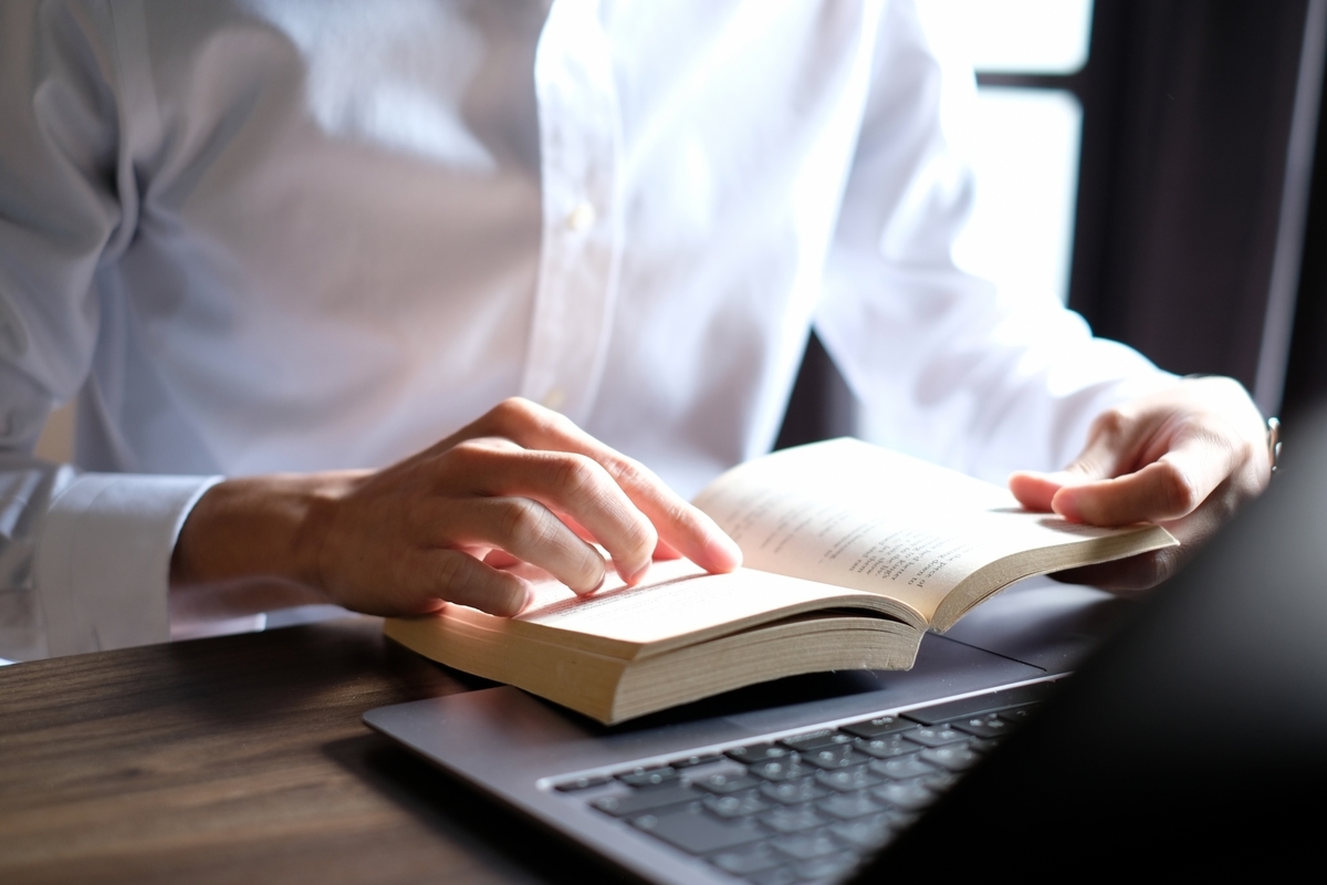 本を読みながらパソコンを操作する