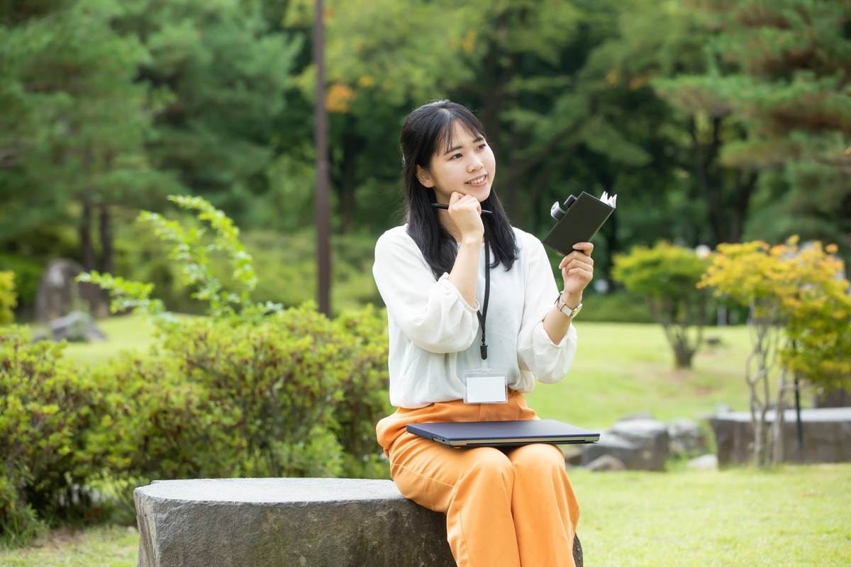 笑顔で手帳に書く女性