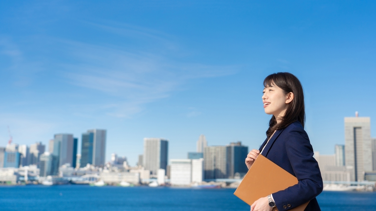 青空とスーツを着た女性
