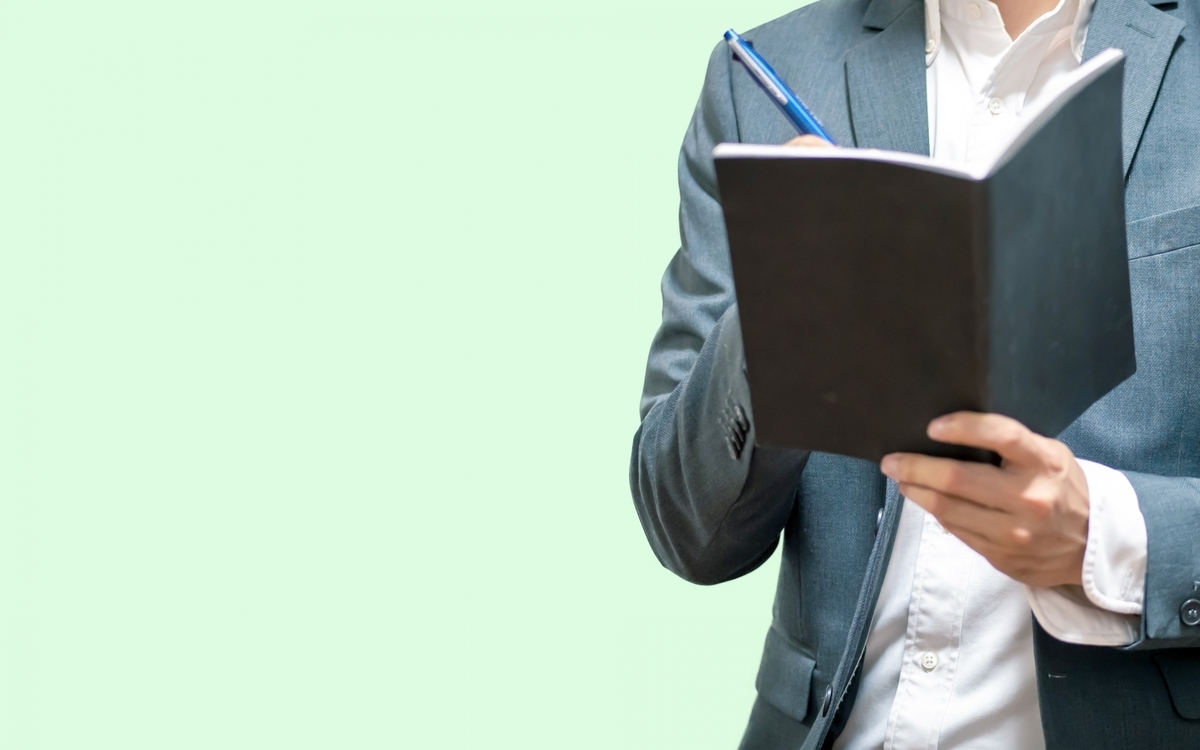 手帳に書き込む男性