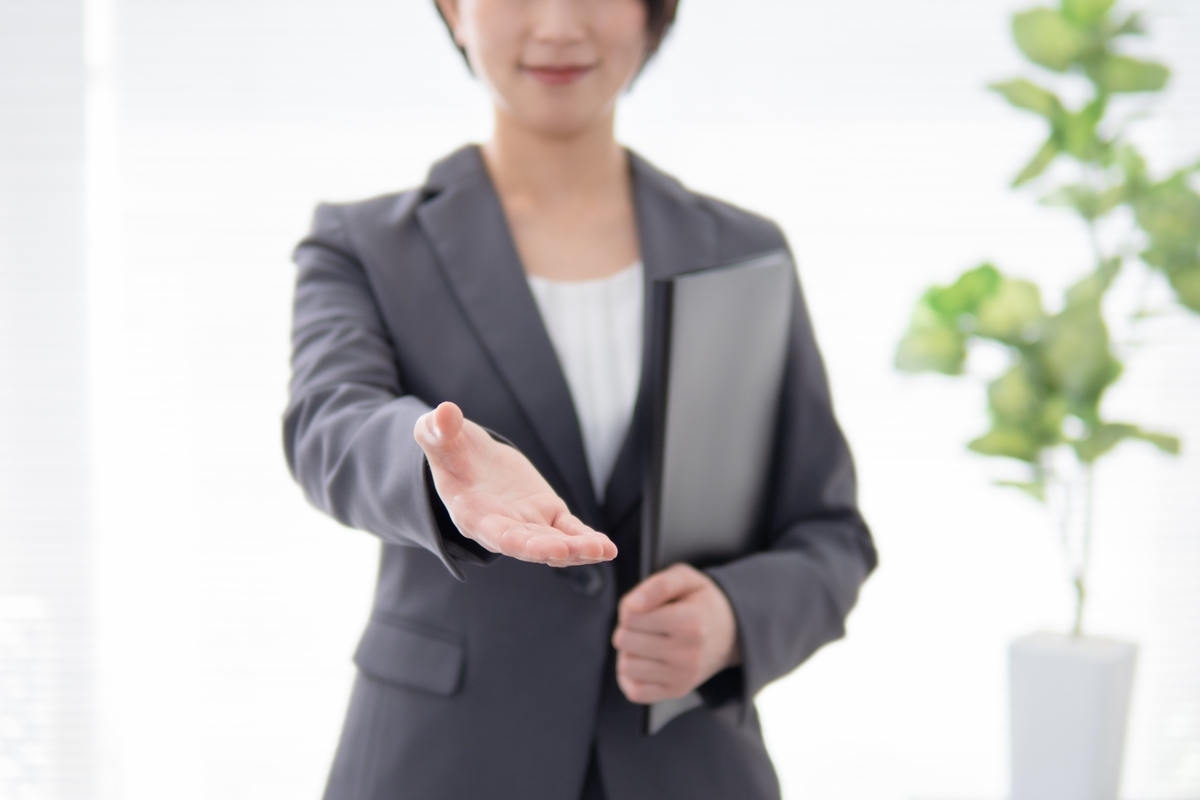 手を差し伸べるスーツの女性