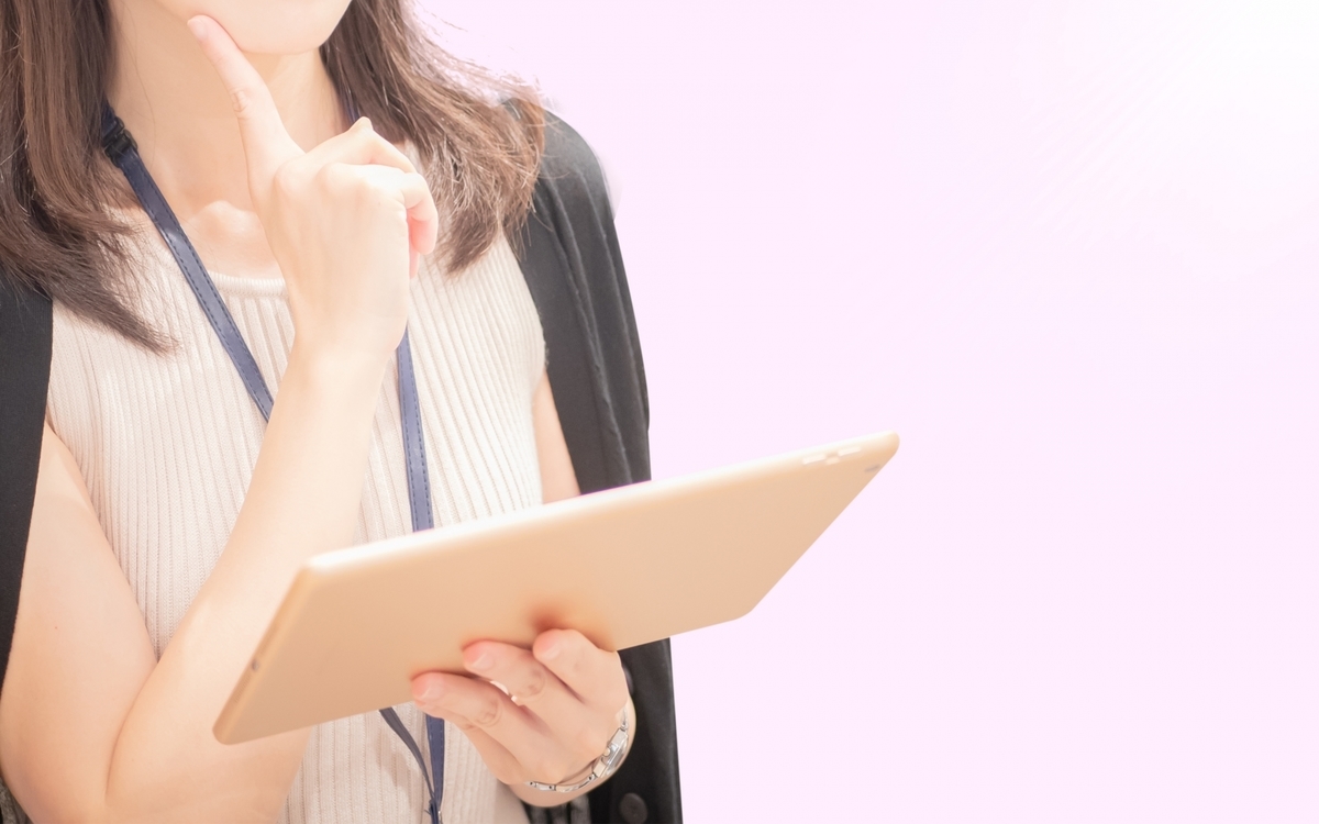 タブレットを手に考え事をする女性