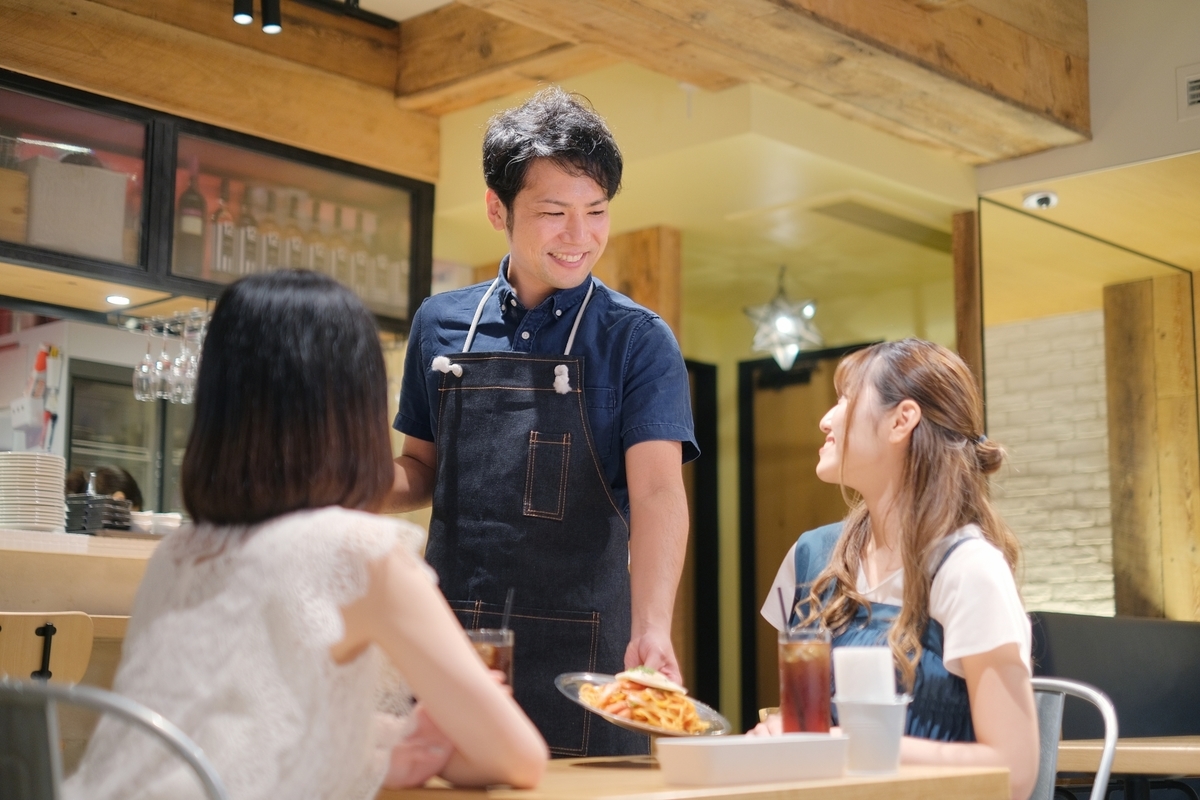 料理を運ぶ男性店員と女性客