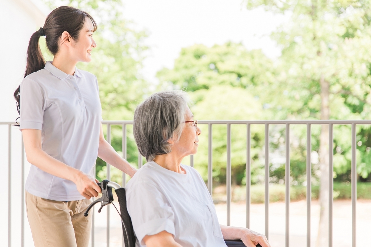 車いすに乗る高齢女性と介護士