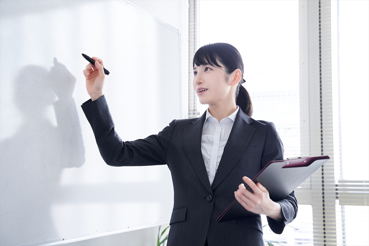 ホワイトボードに記入する女性