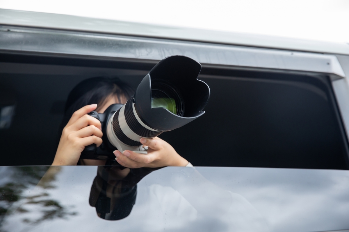 車から写真を撮る人物