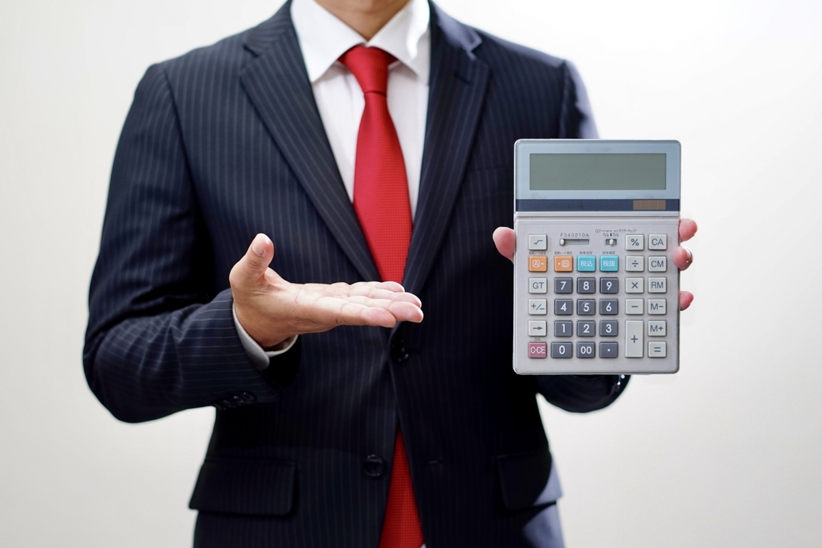 電卓を持つスーツの男性
