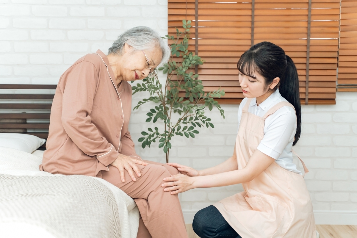 高齢者の体を見る女性