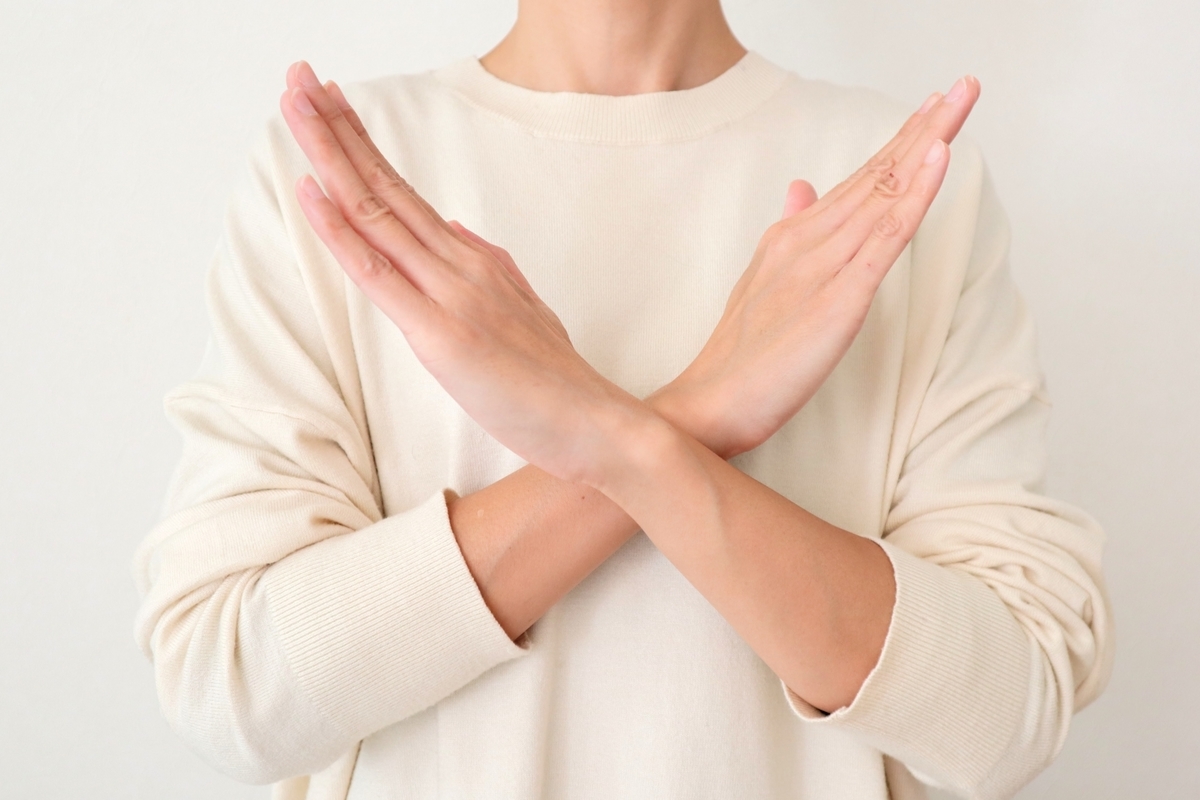 バツ印を作る女性