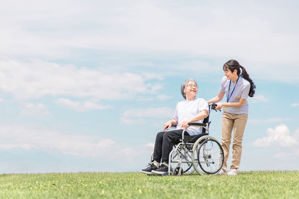 車いすを押す介護士の女性