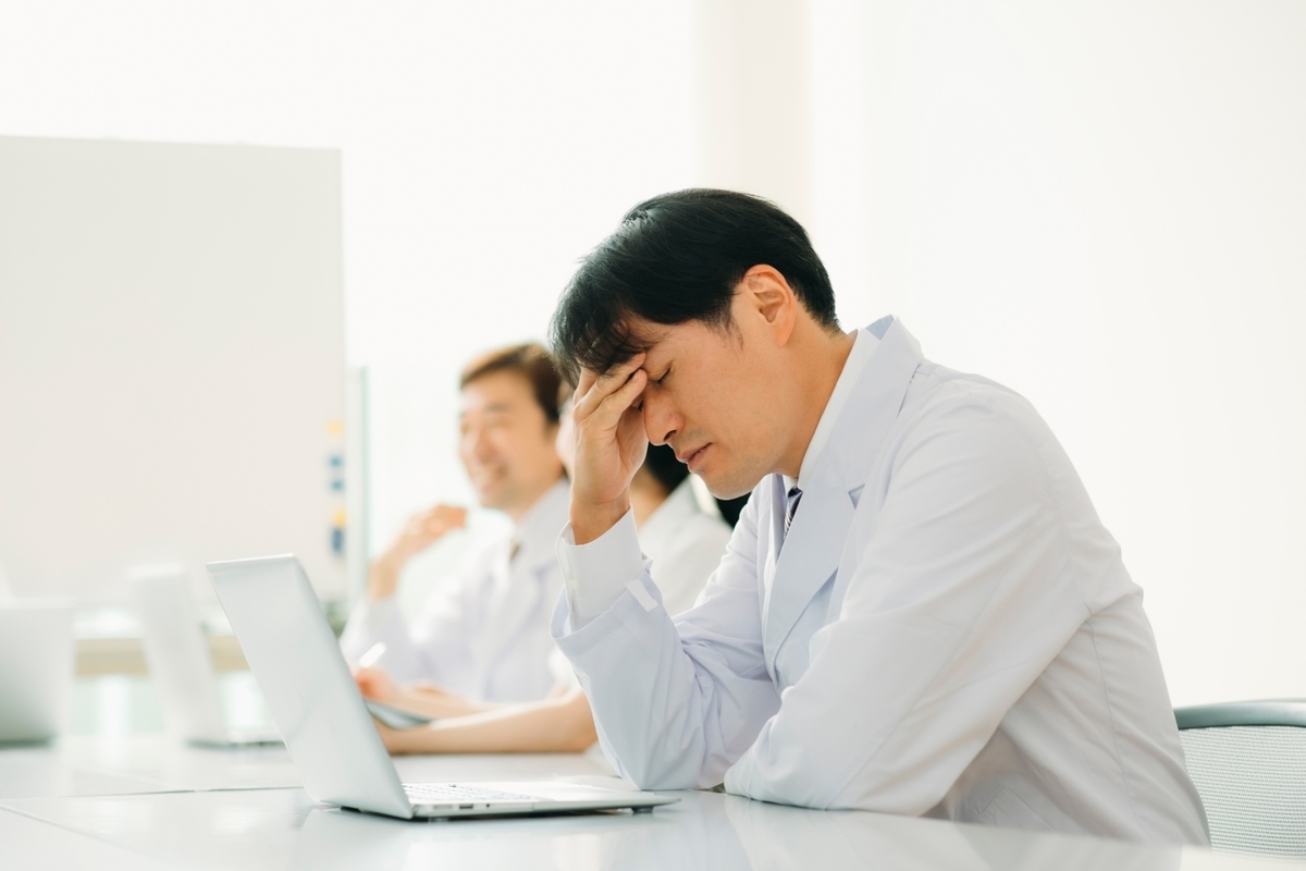 疲れている白衣の男性