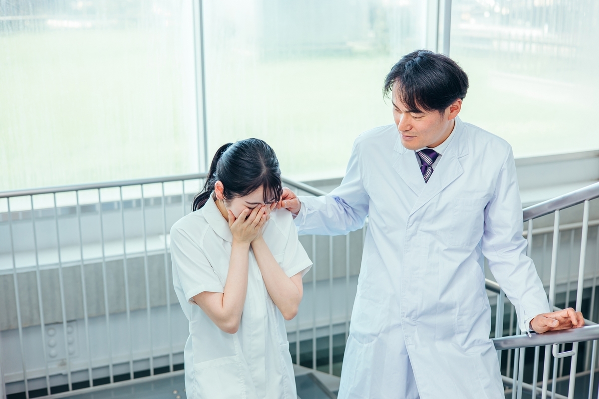 泣く看護師を励ます男性医師