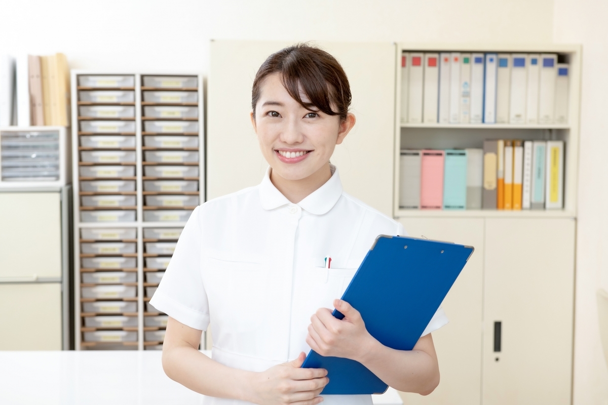 バインダーを持つ白衣の女性