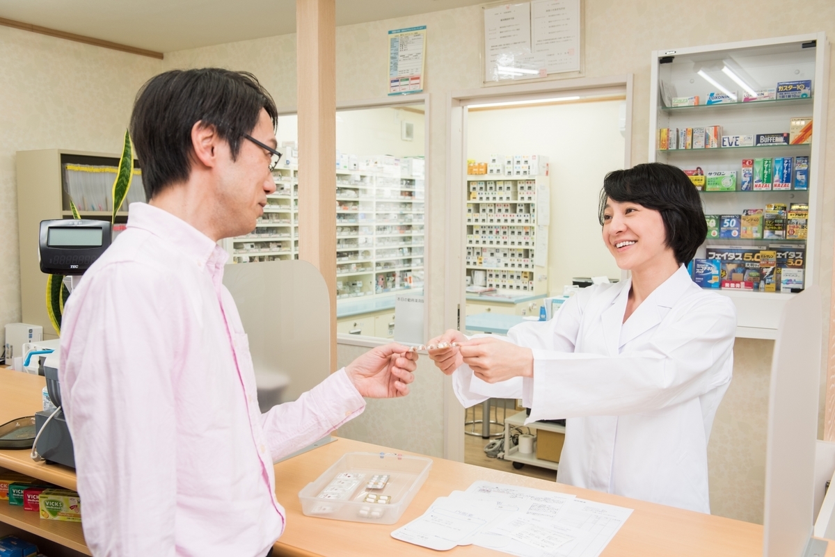 薬を渡す薬剤師の女性