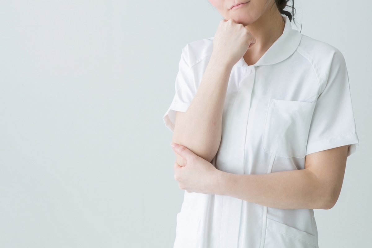 考え事をする白衣の女性