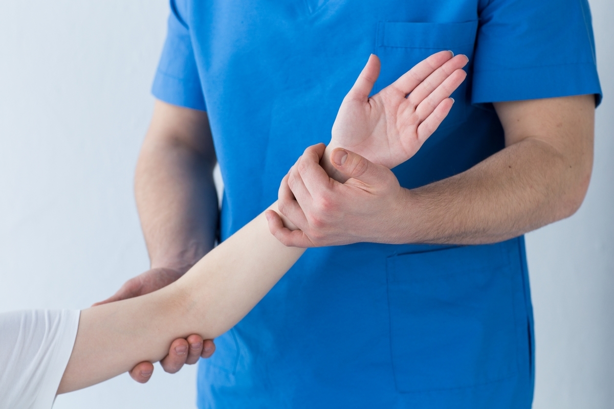 腕のリハビリをする理学療法士