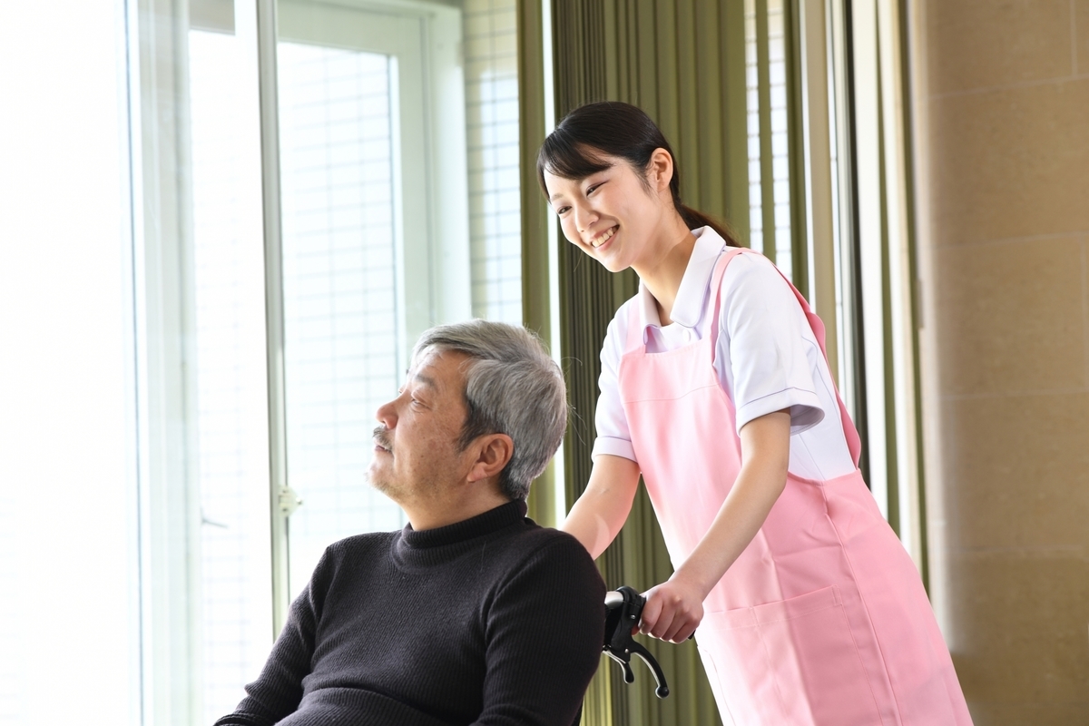 車いすを押す介護士の女性