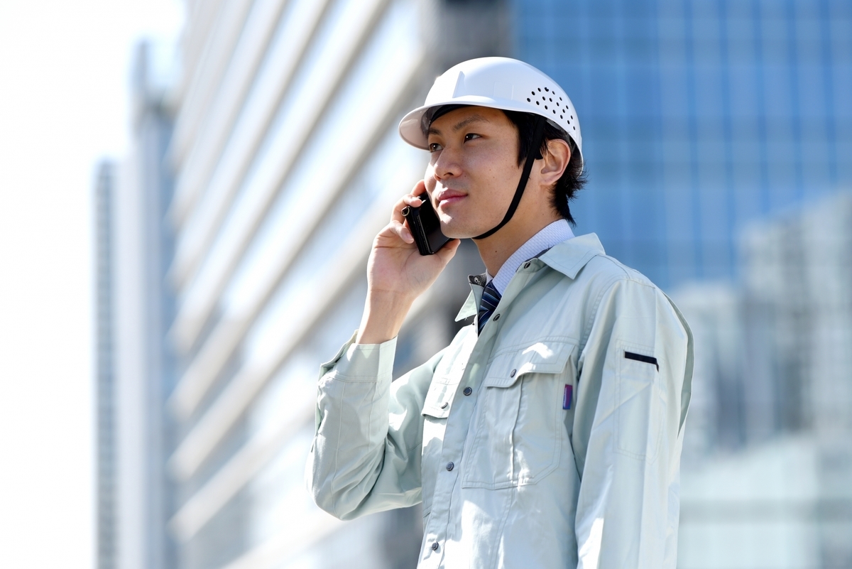 電話をかける作業員の男性