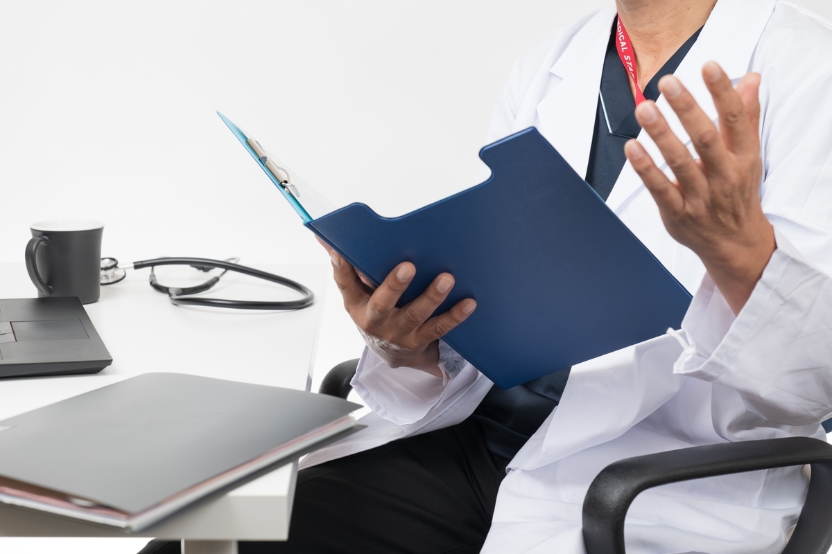 カルテを手にしゃべる医者