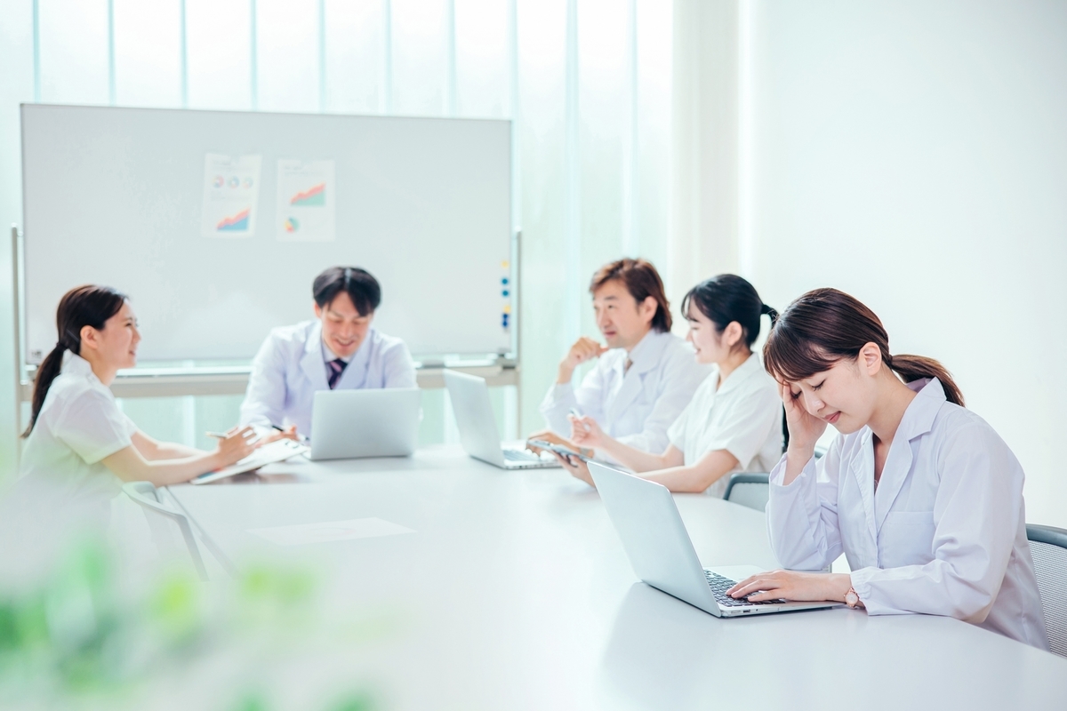 ミーティング中悩む女性看護師