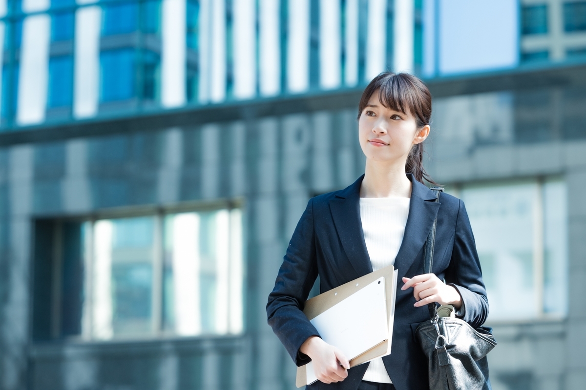 バインダーを持ったスーツの女性