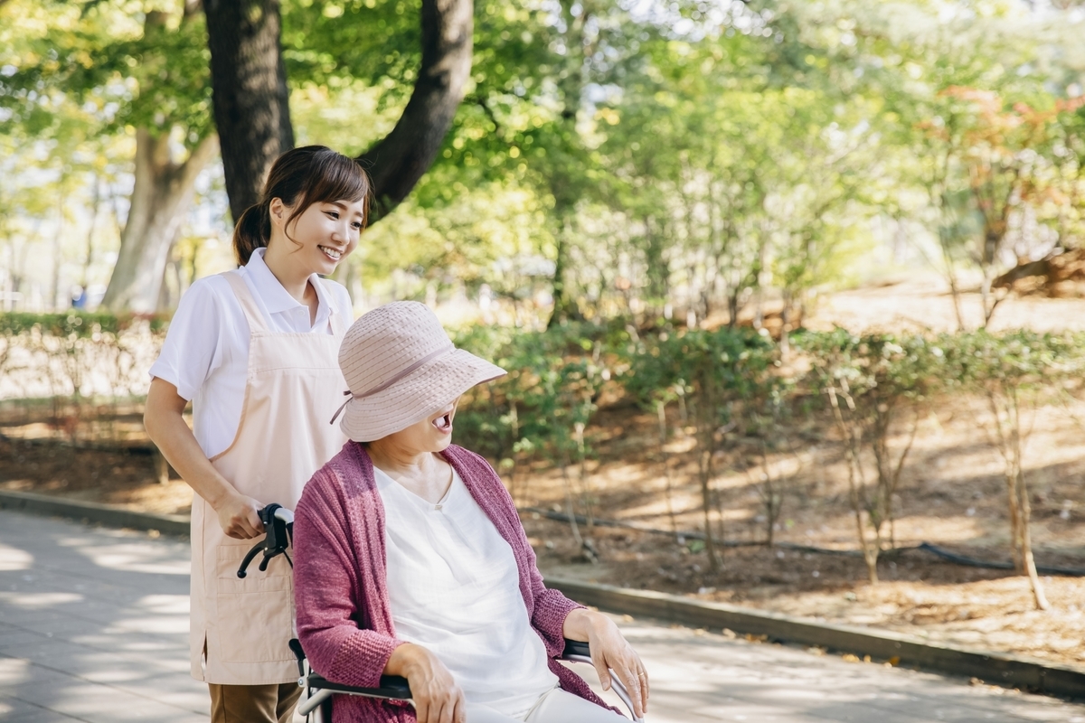 車いすを押す介護士の女性
