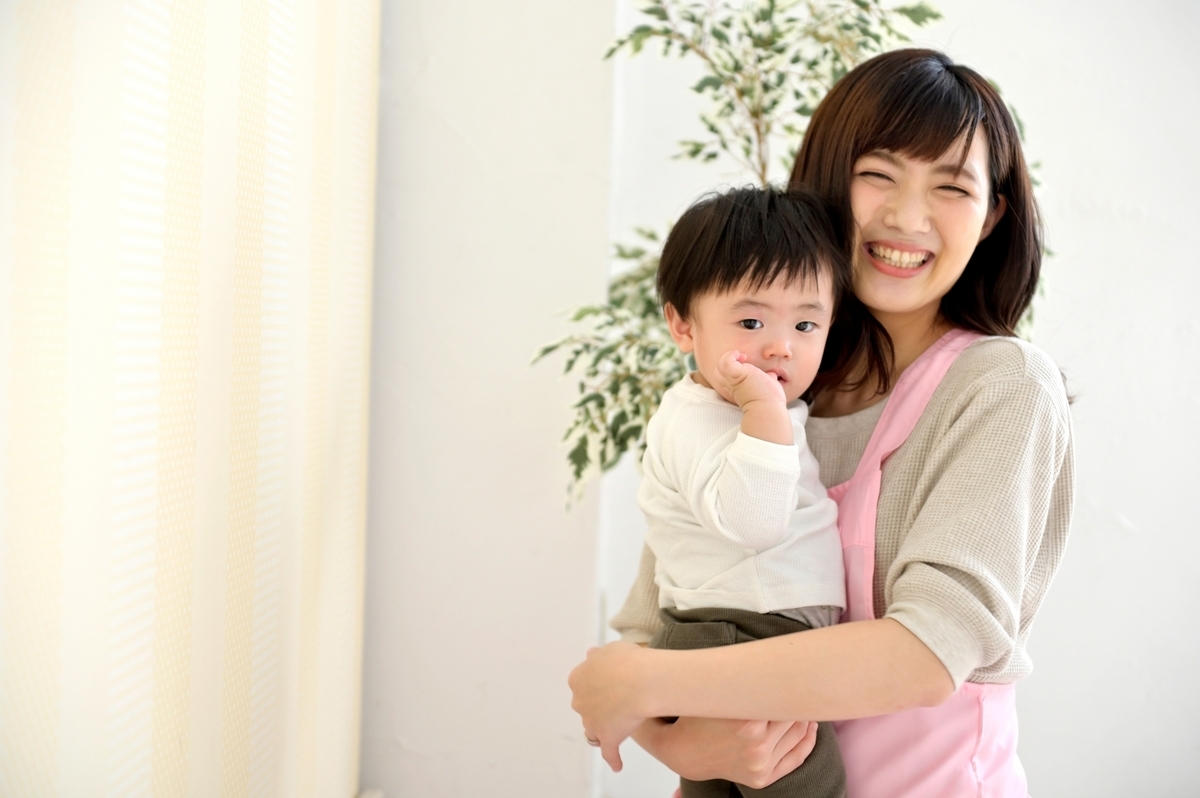 子どもを抱いた女性保育士