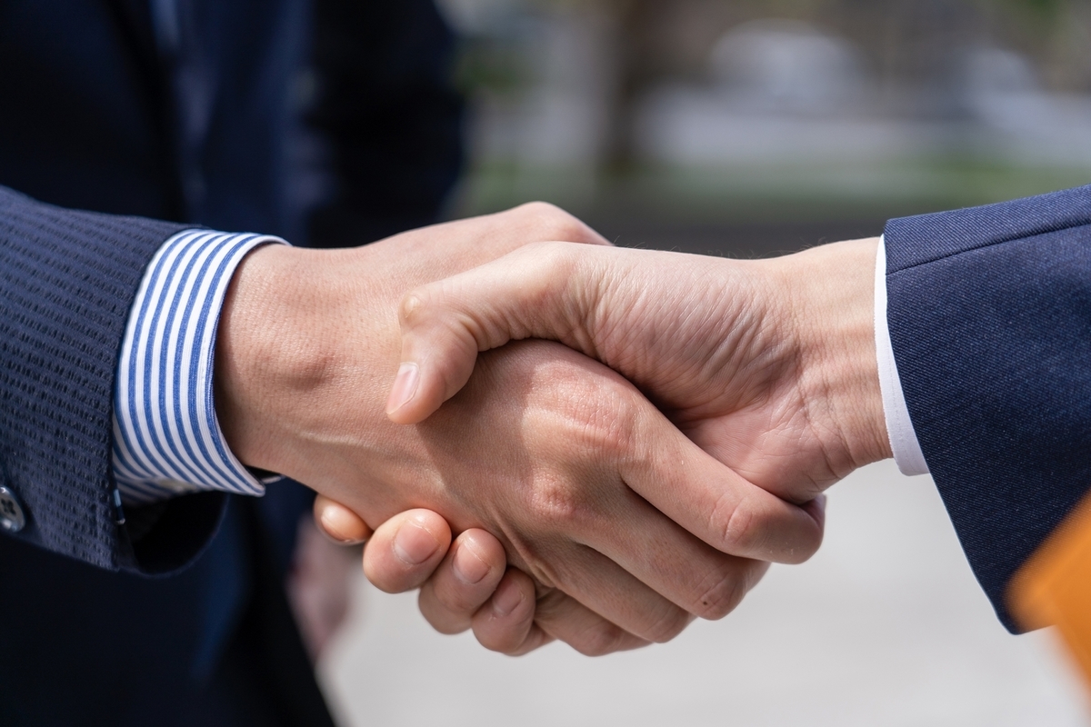 握手するスーツの男性