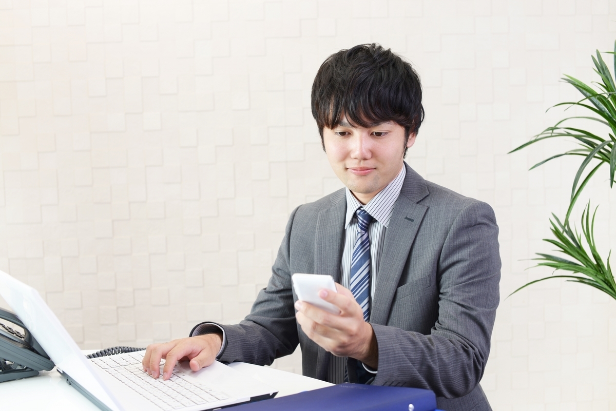 スマホとパソコンを操作する男性