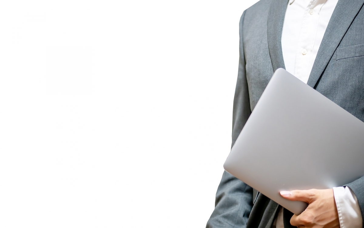 パソコンを運ぶビジネスパーソン